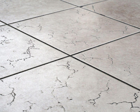 Cracked floor tile caused by poor tile installation and weak adhesive bonding.