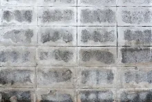 Professional installing outdoor floor tiles using VURA tile adhesive in suitable weather conditions.